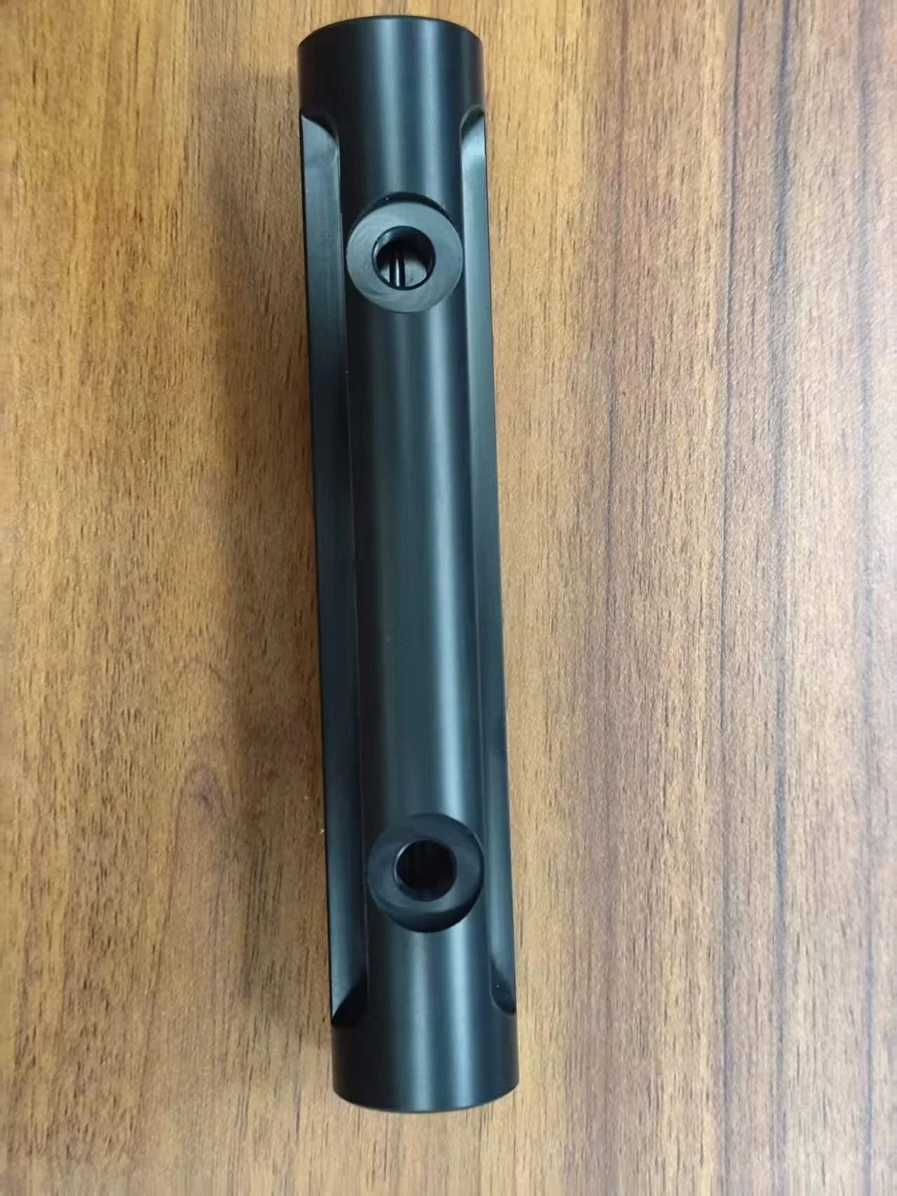 Long black POM mounting component with milled side features